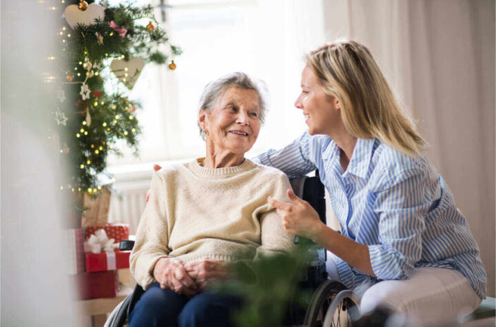 An old lady spending time with an aide in the holiday retirement home.